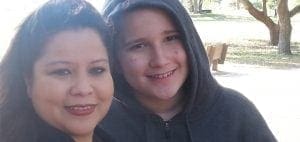 Richie and his mother smiling outdoors.