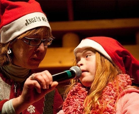 DeAnna Pursai and Cassie Wootan hold a microphone for a performance.