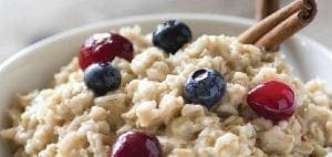 Oatmeal with blueberries, cranberries, and cinnamon sticks.