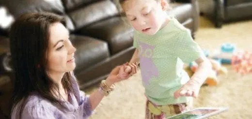 Woman and child look at a tablet in a living room.