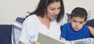Woman reading a book to a child.