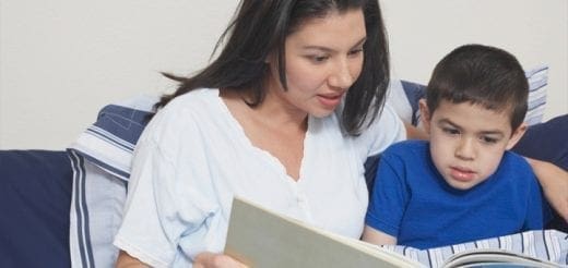 Woman reading a book to a child.