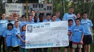 Group of children and teens wearing blue t-shirts and holding a sign that says "Spread the Word to End the Word.