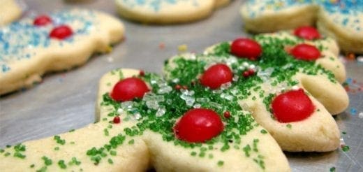 Sugar cookies decorated with red candies and green and white sprinkles.