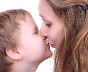 Mother and son kissing with eyes closed