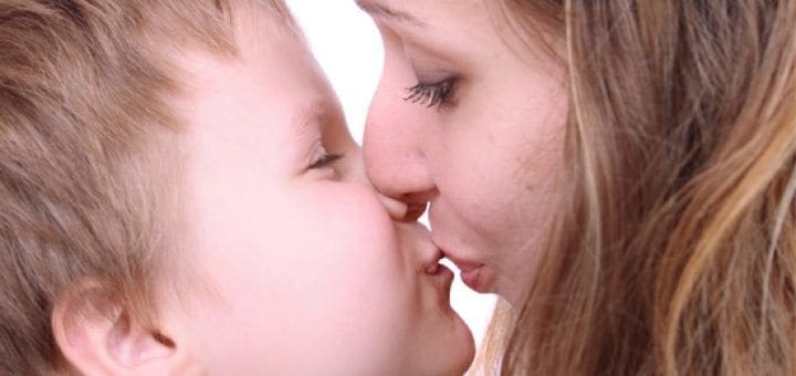 Mother and son kissing with eyes closed
