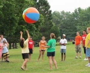 Group of people playing with a large beach ball outdoors.
