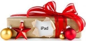 A holiday gift-wrapped iPad with red ribbon and ornaments.