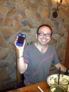 Michael holding a blue smartphone.
