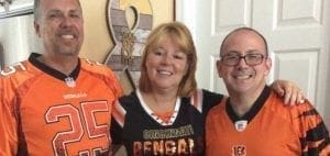 Robin Raiff with two men in Cincinnati Bengals jerseys.