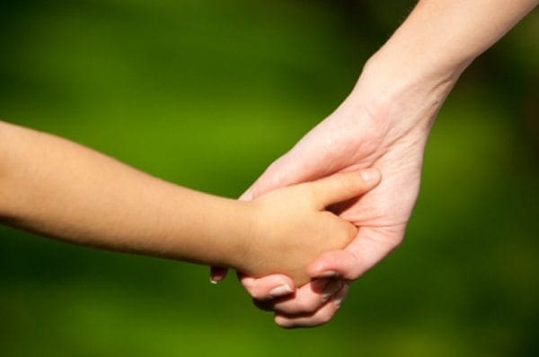 Adult and child holding hands