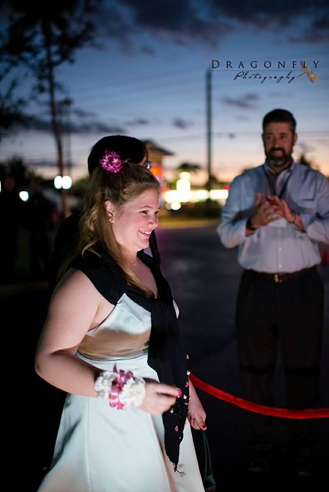 Woman in a white dress and man in a blue shirt at an outdoor event