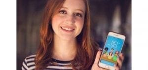 Natalie Hampton holding a phone displaying the 'Sit With Us' app.