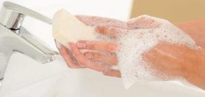 Hands being washed with soap and water.