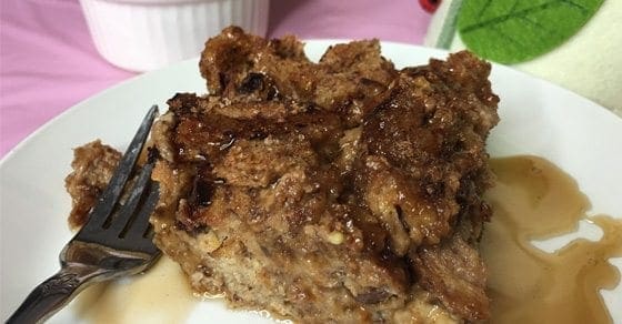 Slice of peanut and apple butter French toast bake with syrup on a white plate.