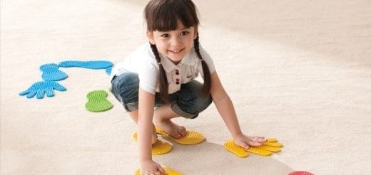 Young girl playing with colorful floor markers.