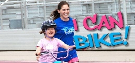 A girl with a helmet on a bicycle with a woman behind her and "I CAN BIKE!" text.
