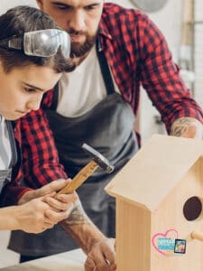 Man and boy build a birdhouse together.
