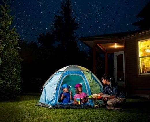 Family camping in the backyard at night.