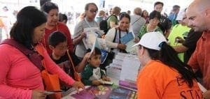 Adults and children at a table with brochures and informational materials.