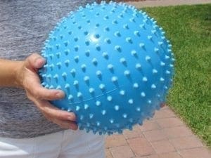 Blue textured fitness ball held by a person