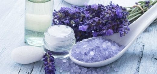 Lavender bath salts, cream, and oil on a wooden surface.