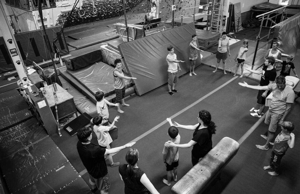 A group of people practicing parkour in a gym.