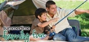 A man and a boy fishing outdoors with a tent behind them.