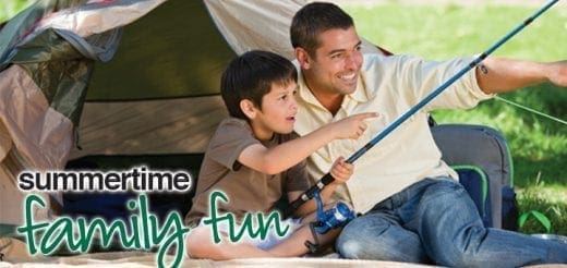 A man and a boy fishing outdoors with a tent behind them.