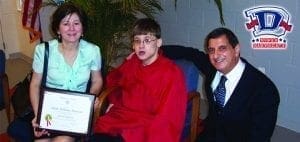 Tony Mancuso with a woman holding a certificate and a young person.