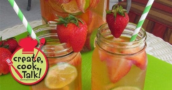 Strawberry and lime infused water in mason jars with fresh fruit and striped straws.