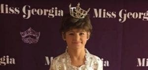 Kelsey Norris wearing a crown and pageant dress.