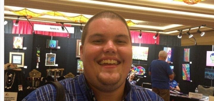 Michael Lincoln-McCreight smiling in front of an exhibit