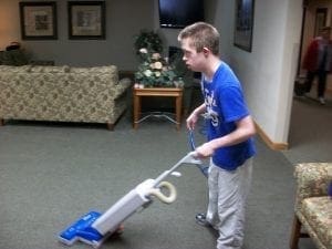 Nick vacuums a carpeted room.