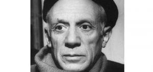 Pablo Picasso wearing a hat and scarf.