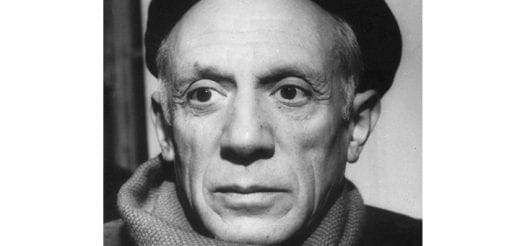 Pablo Picasso wearing a hat and scarf.
