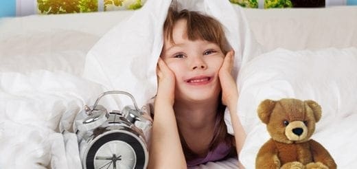 Child in bed with an alarm clock and teddy bear