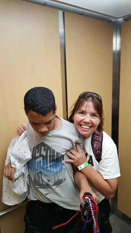 Two people smiling together inside an elevator.