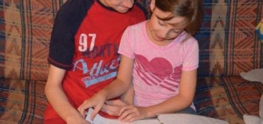 Two children sitting together on a couch.