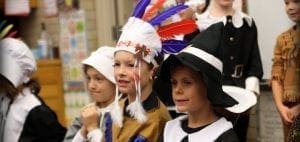 Children in holiday costumes stand in a line.