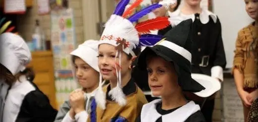Children in holiday costumes stand in a line.