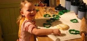 Young girl smiles while making holiday cookies.