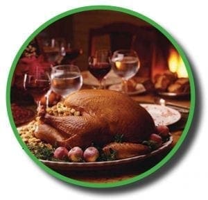 A roasted Thanksgiving turkey on a platter with grapes and stuffing.