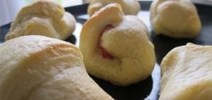 Ham and cheese croissants on a black tray.