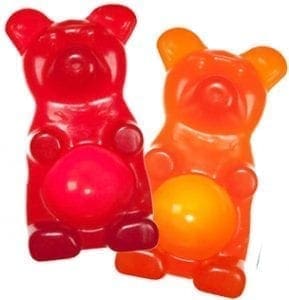 Two gummy bears, one red and one orange, with a bright glow in their bellies.