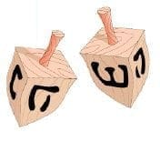 Two wooden dreidels with Hebrew letters.