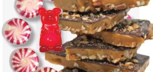 Stack of toffee candy next to peppermint candies and a red gummy bear.