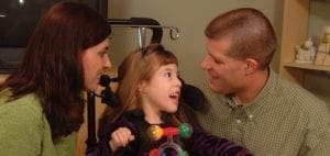 Parents looking at their daughter in a wheelchair