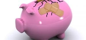 Pink piggy bank with cracks and band-aids