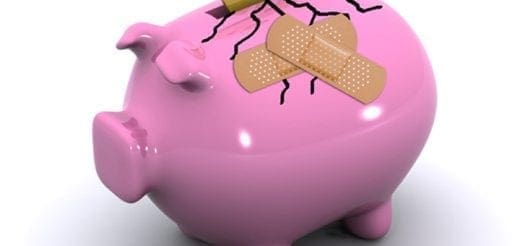 Pink piggy bank with cracks and band-aids